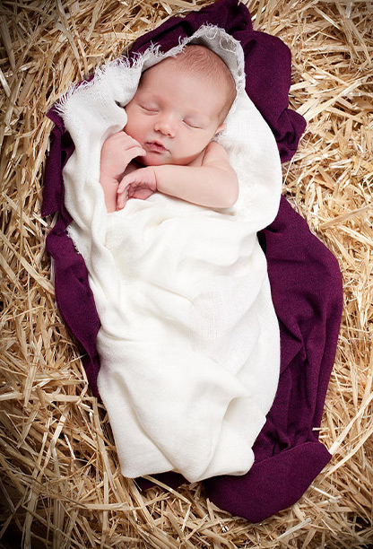 Em bé nằm ngủ trong máng cỏ